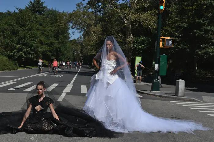 Women pose in bridal dresses in Central Park